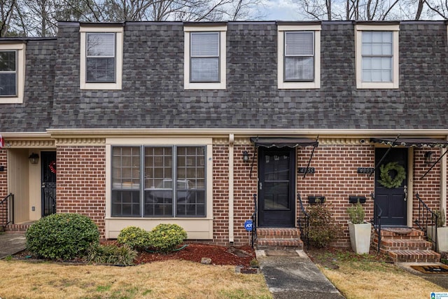 multi unit property with entry steps, brick siding, roof with shingles, and mansard roof