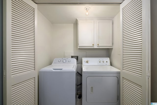 clothes washing area featuring cabinet space and washing machine and clothes dryer