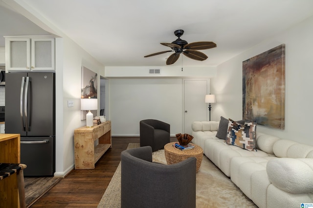 living room featuring baseboards, ceiling fan, visible vents, and dark wood-type flooring