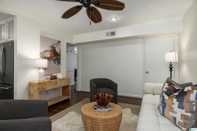 living area featuring dark wood-style flooring, visible vents, and a ceiling fan