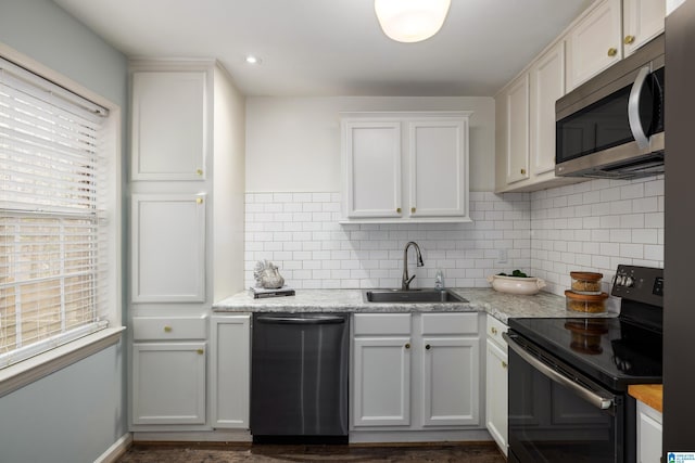 kitchen featuring dishwashing machine, black / electric stove, a sink, white cabinets, and stainless steel microwave