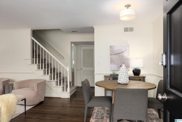 dining space with dark wood-style floors, ornamental molding, stairway, and visible vents