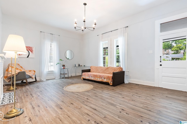 interior space with a healthy amount of sunlight, an inviting chandelier, and wood finished floors