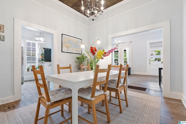 dining room featuring baseboards, wood finished floors, and a notable chandelier