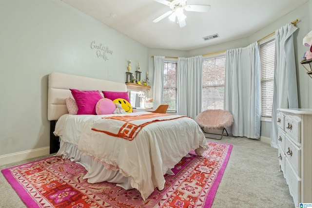 bedroom featuring light carpet, baseboards, visible vents, and a ceiling fan