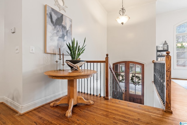 entrance foyer featuring crown molding, baseboards, wood finished floors, and french doors