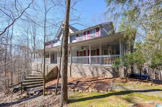 farmhouse-style home featuring covered porch, ceiling fan, and stairs