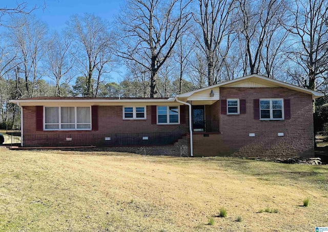 view of front of property featuring a front yard, crawl space, brick siding, and driveway