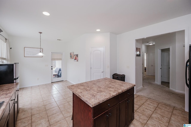 kitchen with hanging light fixtures, a healthy amount of sunlight, light countertops, and a center island