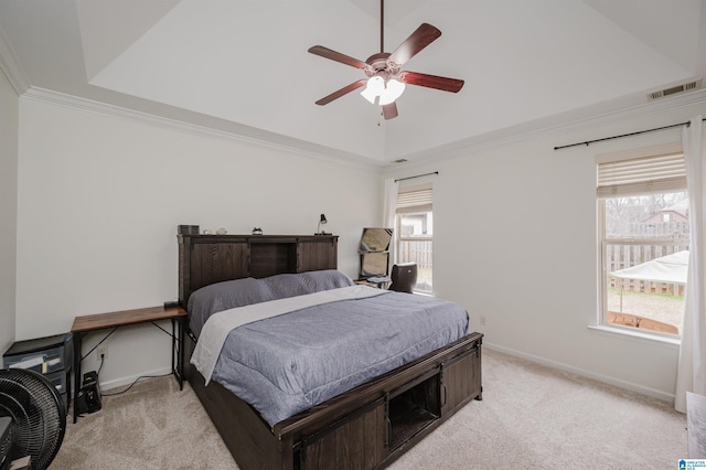 bedroom featuring light carpet, visible vents, baseboards, ornamental molding, and a tray ceiling