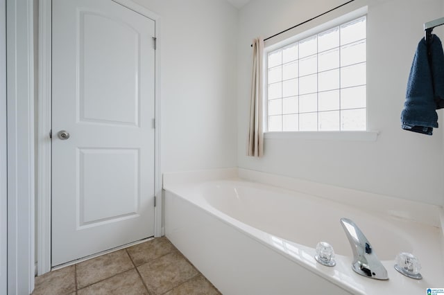 bathroom with a bath, tile patterned flooring, and a wealth of natural light