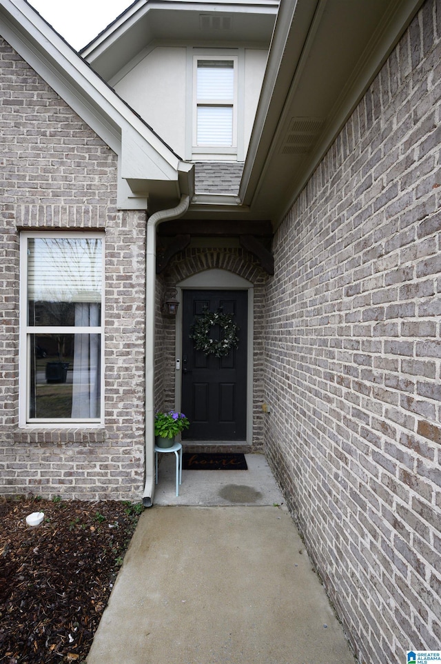 doorway to property with brick siding