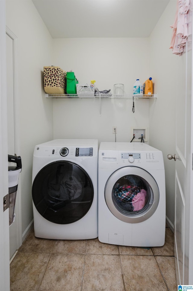 washroom featuring laundry area, washer and clothes dryer, and baseboards