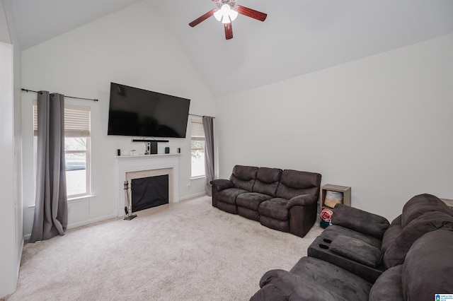 living area featuring a fireplace, light carpet, ceiling fan, high vaulted ceiling, and baseboards