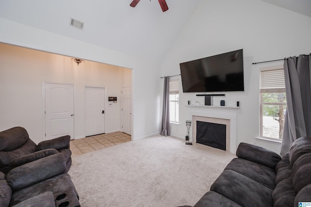 living area featuring light carpet, high vaulted ceiling, plenty of natural light, and visible vents