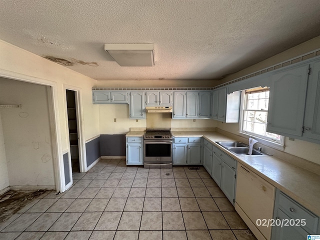 kitchen with stainless steel stove, light countertops, white dishwasher, a sink, and under cabinet range hood