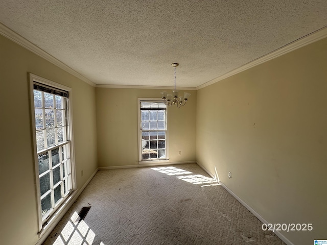 carpeted empty room with a textured ceiling, ornamental molding, baseboards, and an inviting chandelier