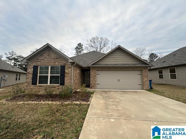 view of front of property with driveway, an attached garage, a front lawn, and brick siding