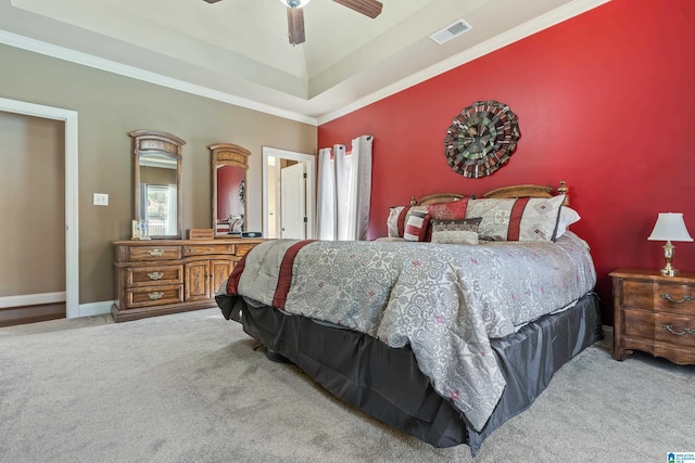 bedroom with light colored carpet, a ceiling fan, baseboards, visible vents, and a raised ceiling