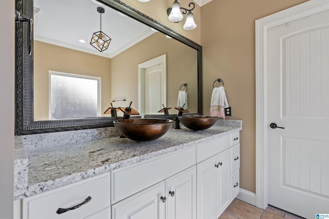 bathroom with double vanity, ornamental molding, tile patterned flooring, and a sink