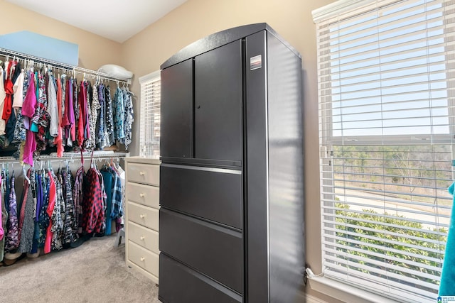 walk in closet featuring light carpet