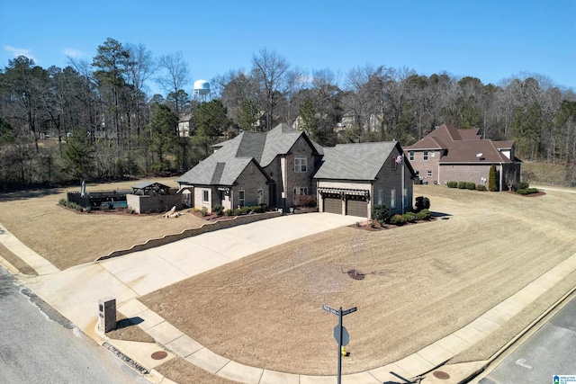 view of front of home with a garage, stone siding, and concrete driveway