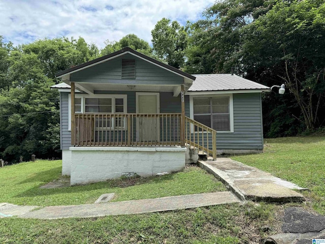 bungalow featuring metal roof, a porch, and a front lawn