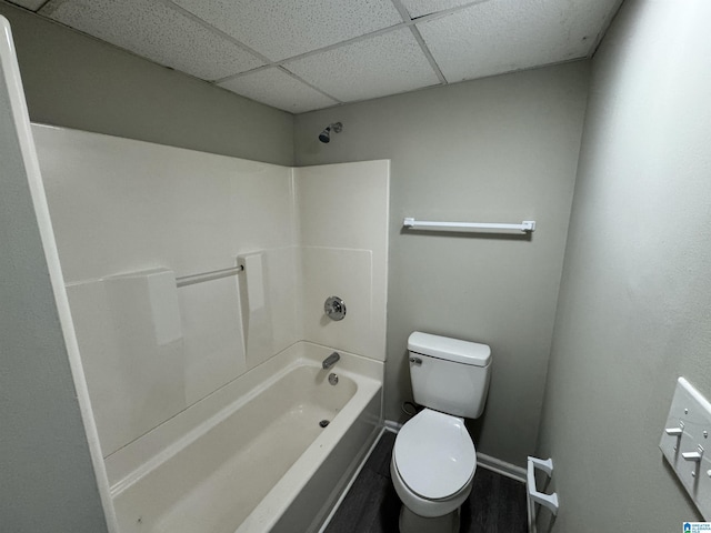 bathroom with a paneled ceiling, toilet, and shower / bathtub combination