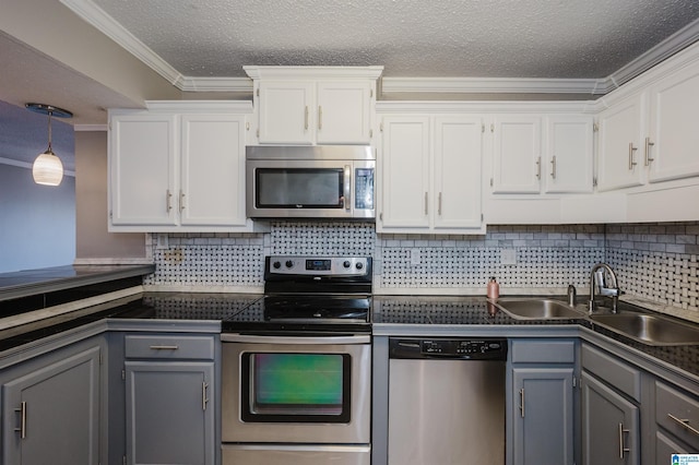 kitchen with appliances with stainless steel finishes, dark countertops, gray cabinets, and white cabinets