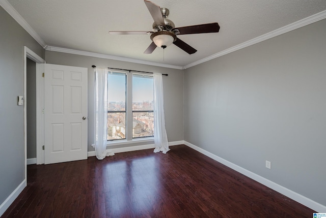 spare room with dark wood-style floors, ceiling fan, baseboards, and crown molding