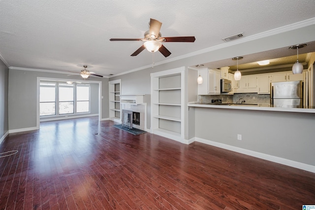 unfurnished living room featuring visible vents, dark wood finished floors, a textured ceiling, and a fireplace