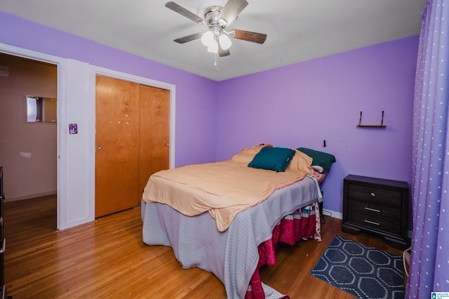 bedroom with a ceiling fan, baseboards, and wood finished floors