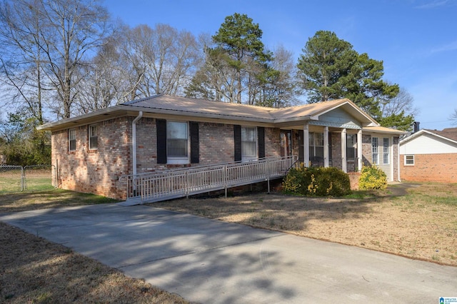 ranch-style house featuring brick siding, metal roof, and a front lawn