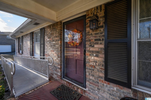 entrance to property featuring covered porch and brick siding