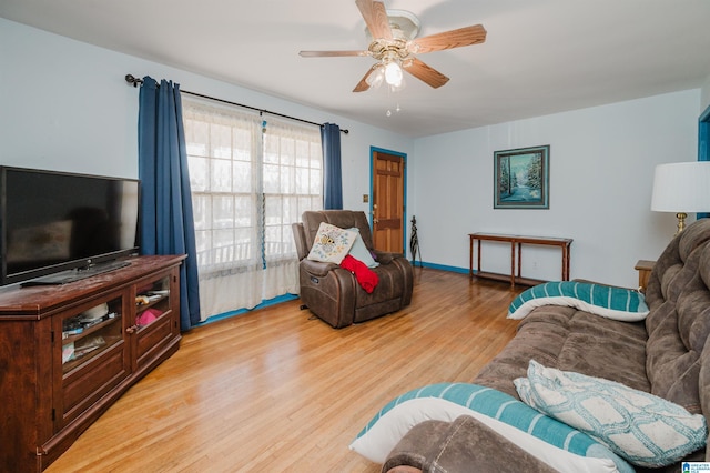 living area featuring light wood-type flooring, ceiling fan, and baseboards