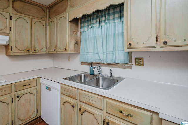 kitchen with dishwasher, light countertops, light brown cabinetry, and a sink