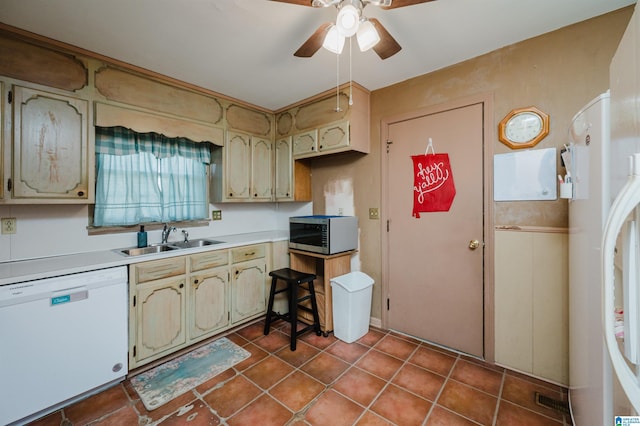 kitchen featuring light countertops, a sink, ceiling fan, white appliances, and tile patterned floors