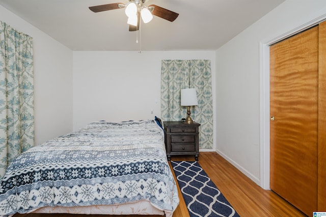 bedroom featuring ceiling fan, wood finished floors, and baseboards