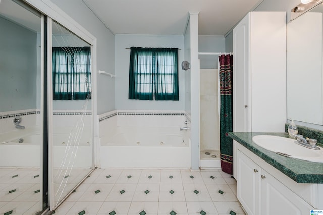 bathroom featuring a tub with jets, a shower stall, and vanity