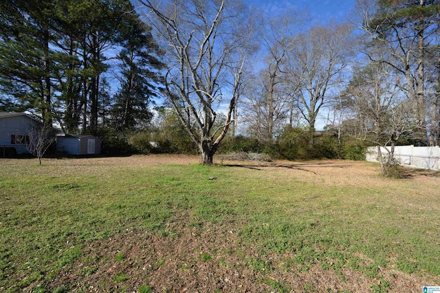 view of yard featuring fence and a storage unit