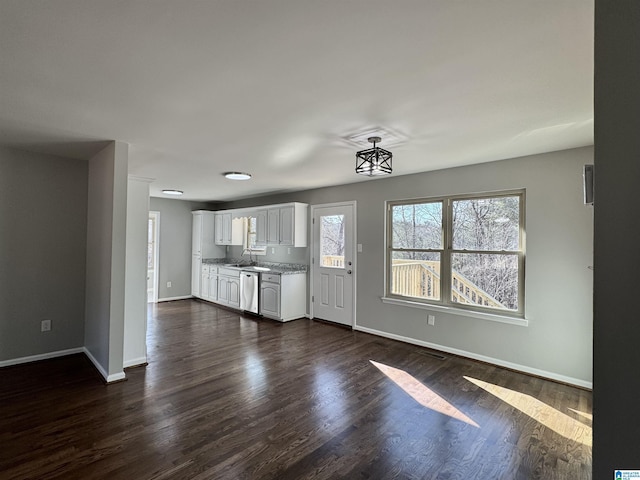 interior space featuring dark wood finished floors, a sink, and baseboards