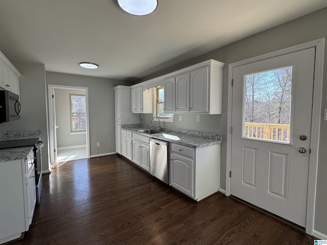 kitchen with a sink, white cabinetry, dark wood-style flooring, and stainless steel dishwasher