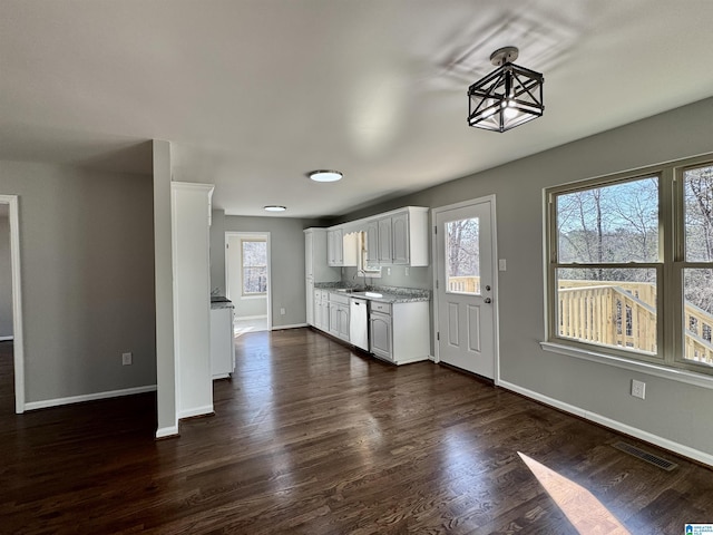 kitchen with a healthy amount of sunlight, visible vents, white cabinets, and dark wood-type flooring