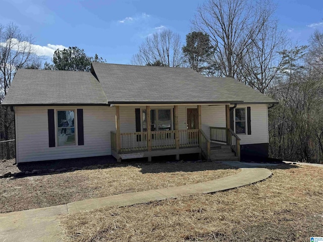 ranch-style house featuring covered porch and roof with shingles