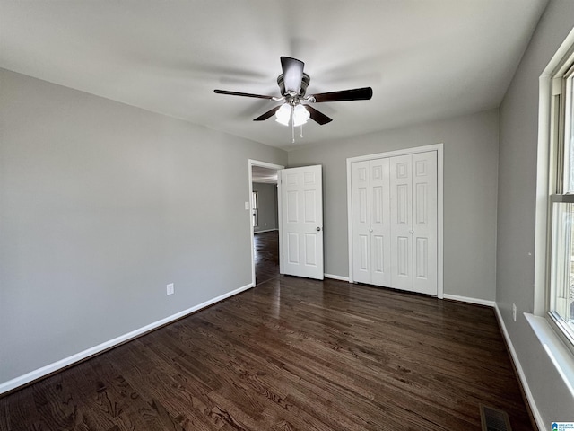 unfurnished bedroom with visible vents, dark wood finished floors, and baseboards