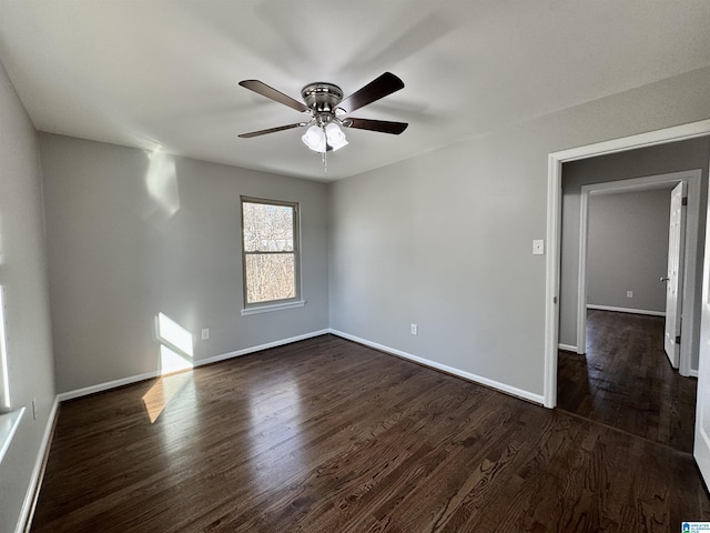 empty room featuring dark wood-style floors, ceiling fan, and baseboards