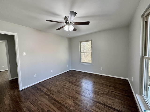 spare room featuring dark wood-style floors, a ceiling fan, and baseboards