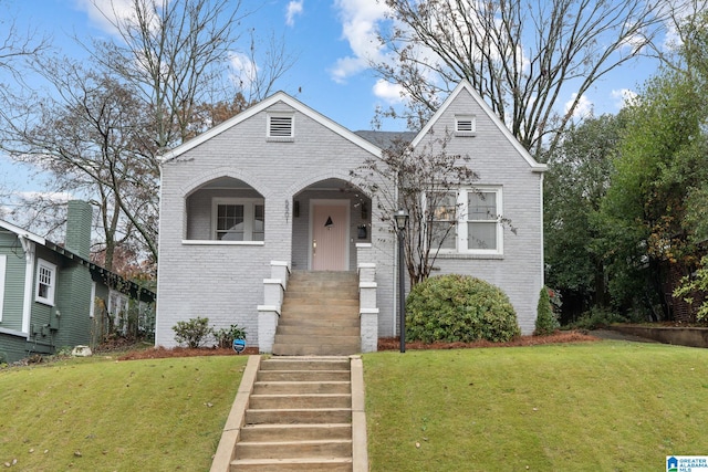 view of front of home featuring brick siding and a front yard