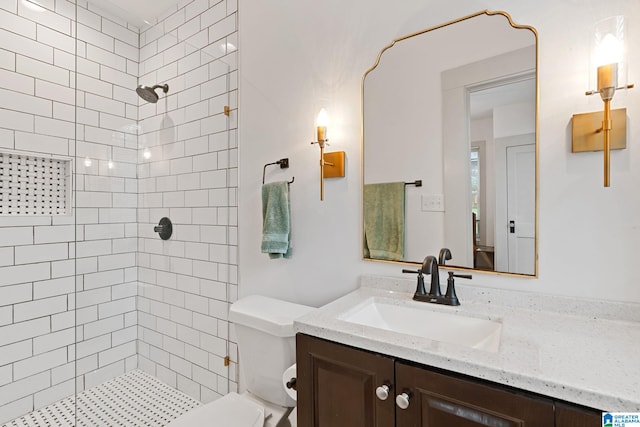 bathroom featuring toilet, a shower stall, and vanity