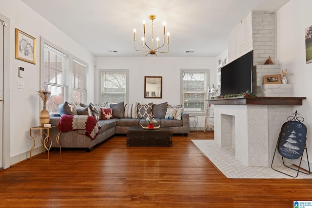 living room featuring a healthy amount of sunlight, a fireplace, and wood finished floors